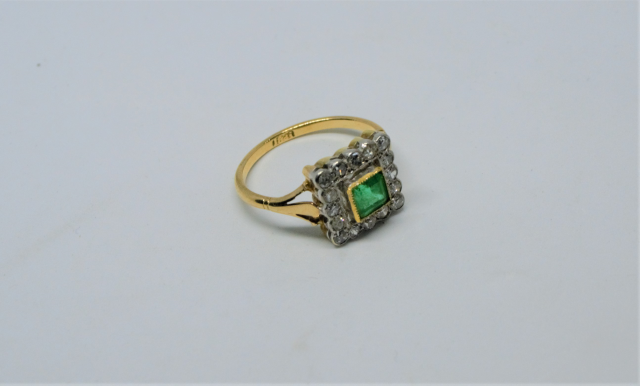 An 18ct Gold Emerald And Diamond Cluster Ring.