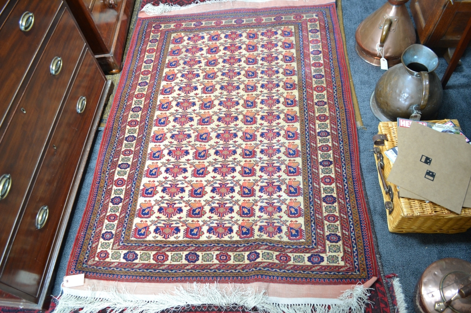 Turkish fringed carpet cream ground with designs in red and blue.