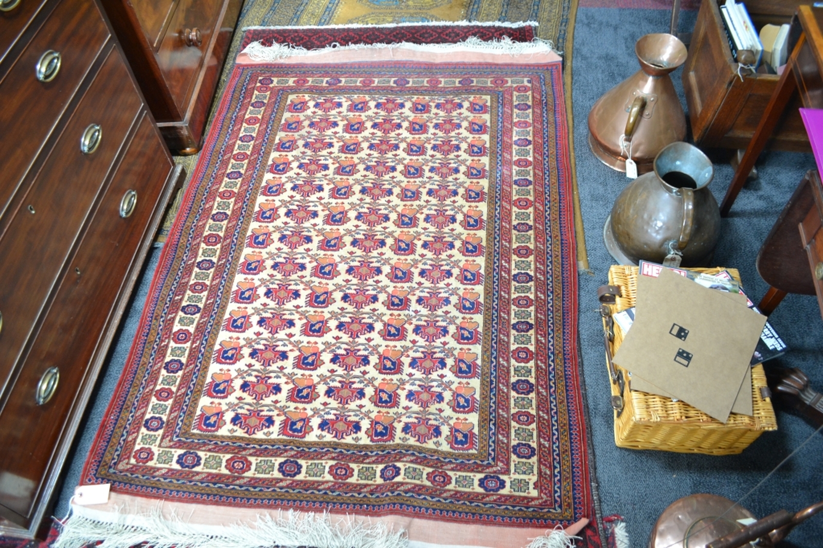 Turkish fringed carpet cream ground with designs in red and blue.
