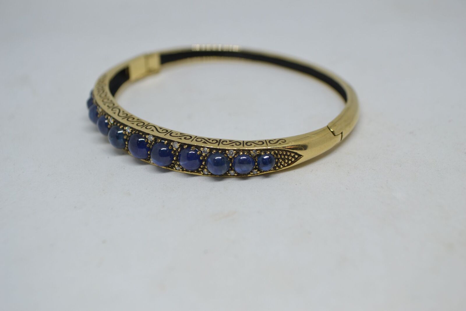 A 9ct yellow gold sapphire bangle