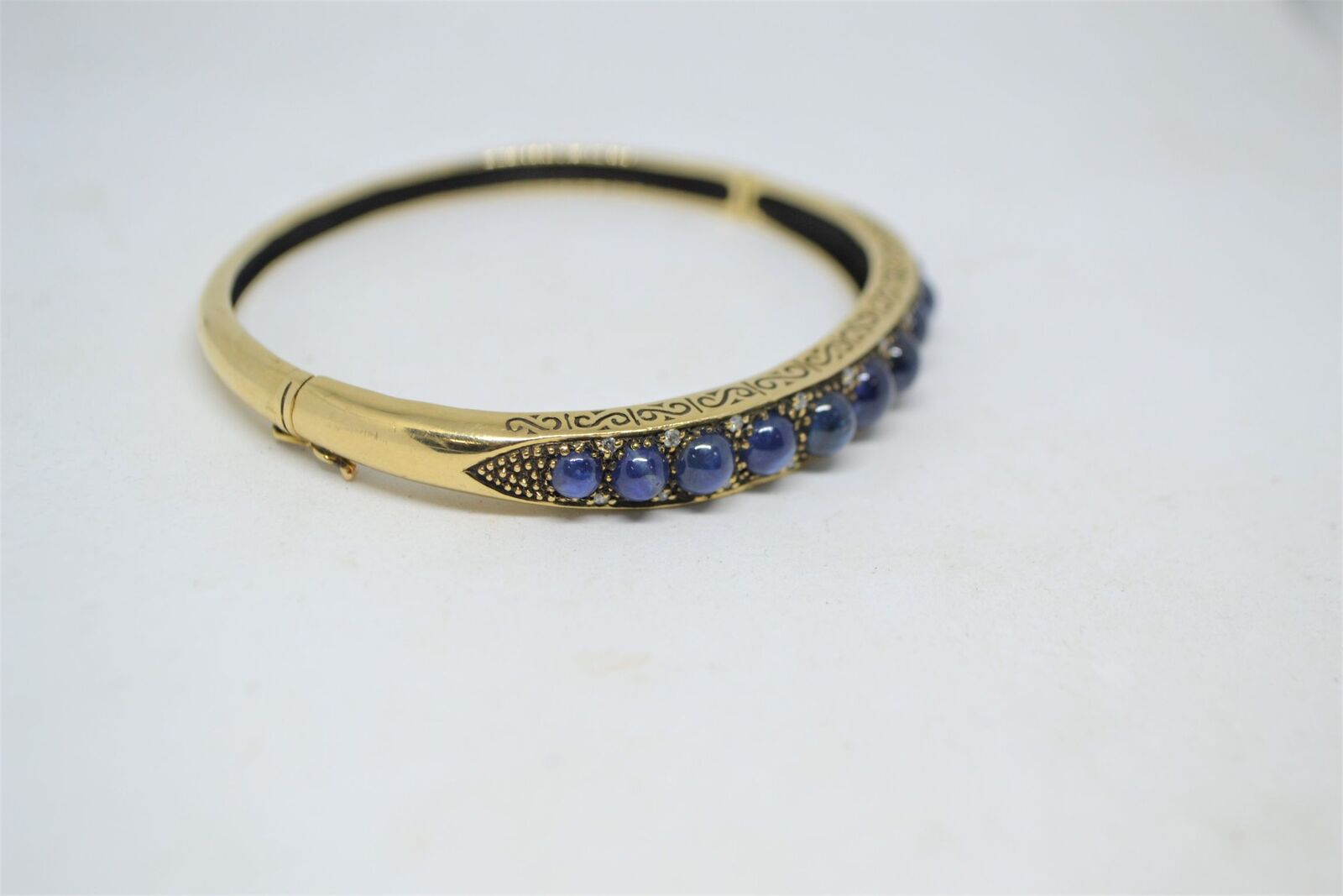 A 9ct yellow gold sapphire bangle